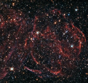 This NASA/ESA Hubble Space Telescope image captures the remnants of a long-dead star. These rippling wisps of ionised gas, named DEM L316A, are located some 160 000 light-years away within one of the Milky Way’s closest galactic neighbours — the Large Magellanic Cloud (LMC). The explosion that formed DEM L316A was an example of an especially energetic and bright variety of supernova, known as a Type Ia. Such supernova events are thought to occur when a white dwarf star steals more material than it can handle from a nearby companion, and becomes unbalanced. The result is a spectacular release of energy in the form of a bright, violent explosion, which ejects the star’s outer layers into the surrounding space at immense speeds. As this expelled gas travels through the  interstellar material, it heats it up and ionise it, producing the faint glow that Hubble’s Wide Field Camera 3 has captured here. The LMC orbits the Milky Way as a satellite galaxy and is the fourth largest in our group of galaxies, the Local Group. DEM L316A is not alone in the LMC; Hubble came across another one in 2010 with SNR 0509 (heic1018), and in 2013 it snapped SNR 0519 (potw1317a).